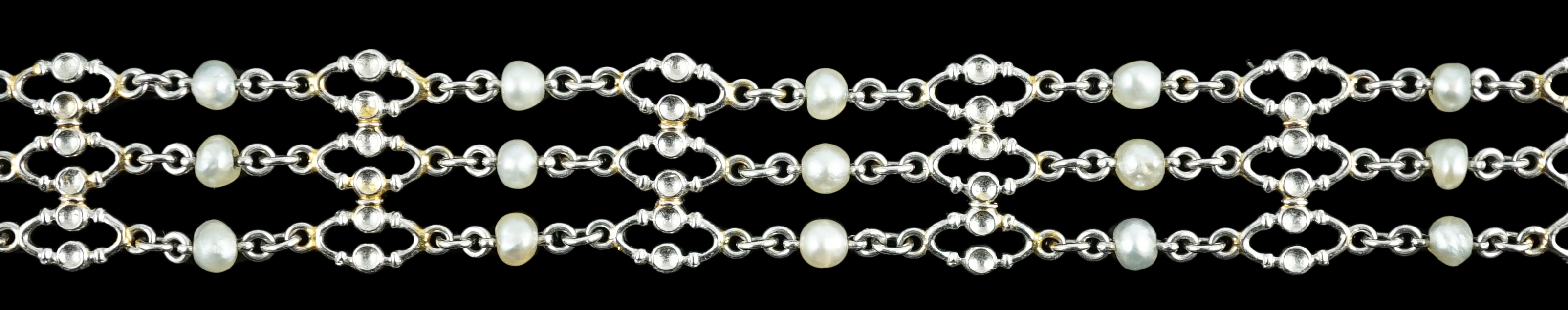 An early to mid 20th century white gold and seed pearl set three row chain link bracelet